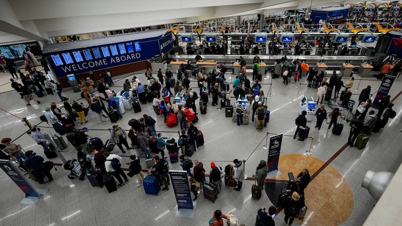 Travelers move through Hartsfield-Jackson Atlanta International Airport, Friday, Dec. 20,...